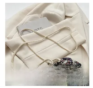 Detail of bohemian woven bucket bag with thick cotton rope strap on stylish blazer