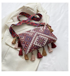 Close-up of ethnic crossbody bag featuring geometric embroidery and colorful tassels