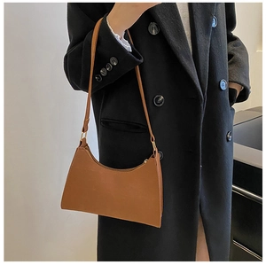 Detail view of brown vintage baguette bag featuring smooth leather and gold hardware
