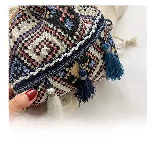 Detailed view of bohemian bucket bag featuring woven geometric patterns and blue tassels
