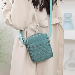 Minimalist green quilted nylon crossbody bag for women with adjustable blue strap