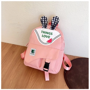 Detailed view of pink school bag featuring checkered bunny ears and watermelon print detail