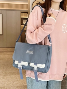 Detail view of the blue canvas tote bag with adjustable shoulder strap and buckle closures