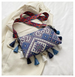 Detail of bohemian crossbody bag showing ethnic geometric weaving and colorful tassels