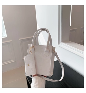Detailansicht der weißen Tasche mit Krokodilprägung, kleinem Beutel und goldener Kette