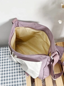 Close-up of spacious purple canvas tote with yellow interior and secure zipper closure