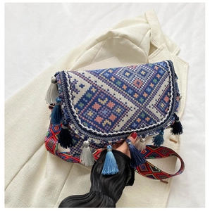 Detail of bohemian woven crossbody bag with colorful geometric patterns and long fringes