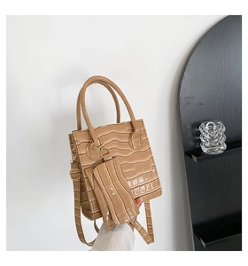 Details einer khakifarbenen Handtasche mit Krokoprägung und kleinem Münzbeutel