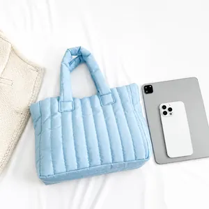Top view of large light blue quilted tote bag with vertical stitching and interior items