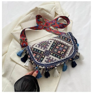 Detail of bohemian crossbody bag with colorful geometric patterns and stylish blue tassels
