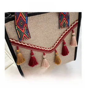 Gros plan du sac en lin avec broderie ethnique et détails de franges à pompons colorés