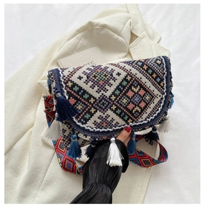 Detailed shot of ethnic crossbody bag with geometric embroidery and blue fringe tassels