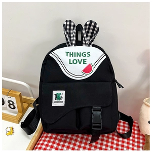 Detail of a kids' backpack with bunny ears, bear patch, and checkered pattern accents