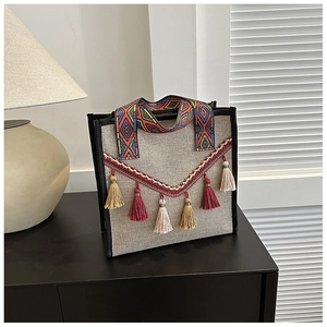 Vue détaillée du sac ethnique avec pompons colorés et poignée tissée géométrique