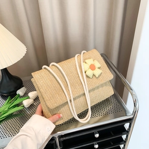 Minimalist straw woven tote bag with fabric flower detail and cotton rope straps
