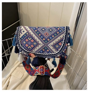 Detail of bohemian jacquard crossbody bag with colorful tassels and wide patterned strap