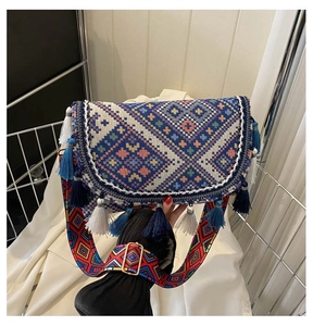 Detail of ethnic geometric woven crossbody bag with colorful tassels and wide strap
