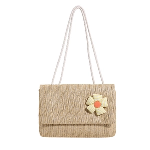 Minimalist straw tote bag with yellow floral decoration and white rope shoulder strap