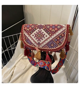 Close-up of bohemian woven handbag featuring tassels and colorful geometric patterns