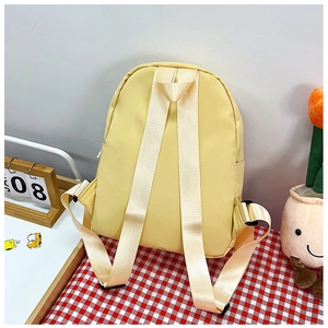 Close-up of bright yellow school backpack with reinforced shoulder straps and textured fabric