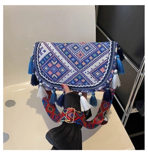 Close-up of geometric woven pattern with fringe and colorful bohemian wide strap bag