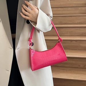 Pink faux crocodile leather handbag with glossy finish and knotted shoulder strap detail