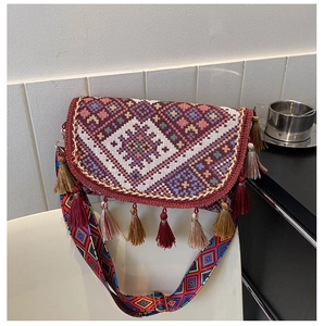 Detail of bohemian crossbody bag with colorful woven patterns and decorative tassels