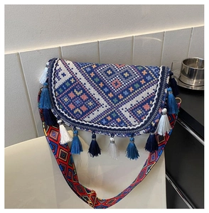 Detailed view of bohemian crossbody bag with ethnic embroidery and colorful tassels