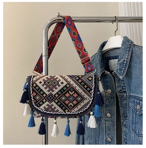 Detailed close-up of ethnic woven crossbody bag with colorful tassels and geometric patterns
