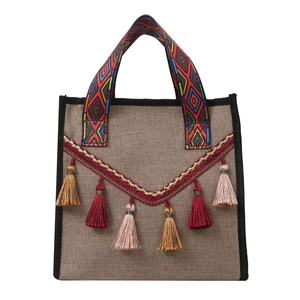 Sac seau en jute ethnique avec pompon et poignées géométriques bohèmes sur fond blanc
