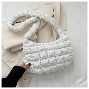 Detail of white quilted puffy cloud bag with pleated handle on beige blazer
