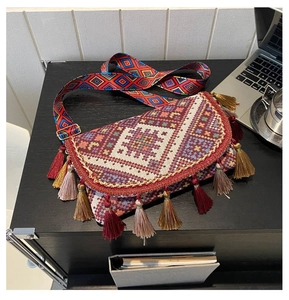 Detail of bohemian woven bag with ethnic geometric patterns and colorful long tassels