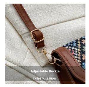 Detail of vintage crossbody bag showing adjustable leather strap with gold buckle