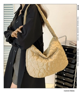 Detail of khaki quilted puffer tote bag showing 3D floral pattern on nylon fabric