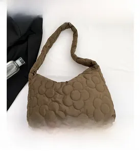 Detail view of deep brown quilted tote bag featuring a modern floral stitching pattern