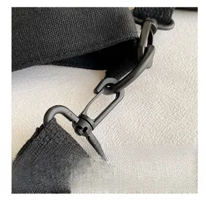 Detailed macro view of the durable black rotating metal swivel hook on a canvas tote bag