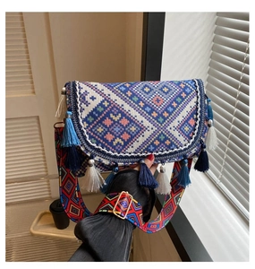 Detail of bohemian crossbody bag showing ethnic geometric jacquard and blue tassel fringe