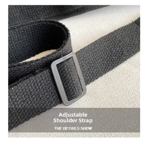 Detail of adjustable black woven shoulder strap with a rectangular plastic buckle