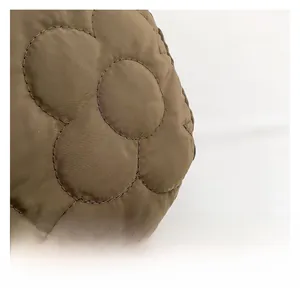 Close-up of brown quilted cloud tote bag fabric with soft petal-shaped stitching
