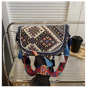 Detailed shot of ethnic crossbody bag featuring colorful tassels and woven pattern
