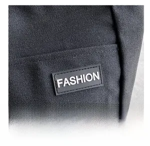 Detailed macro view of the black canvas tote featuring a rectangular Fashion logo label