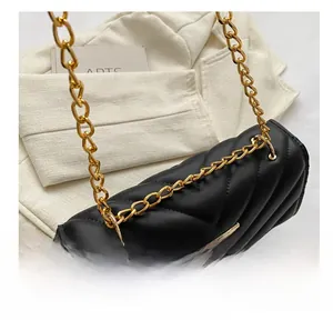 Détail du sac bandoulière noir matelassé avec surpiqûres en V et chaîne dorée chic
