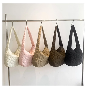 Quilted floral tote bags in five colors hanging on a metal rack showing fabric details