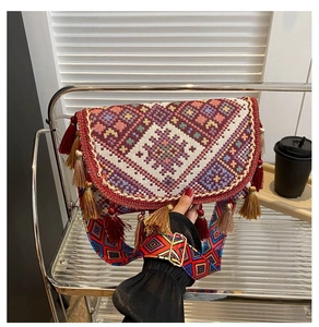 Detailed close-up of ethnic woven crossbody bag with colorful tassels and geometric strap