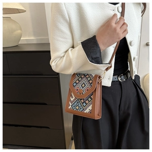 Close-up of vintage ethnic crossbody bag with geometric woven patterns and leather trim