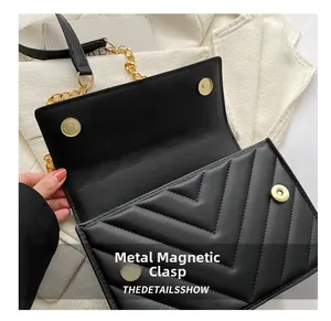 Détails des boucles magnétiques dorées sur sac bandoulière matelassé noir avec chaîne
