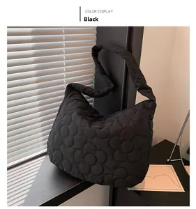 Detail of black quilted tote bag with floral stitching and padded cloud texture