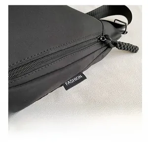 Détail du sac en nylon noir avec fermeture éclair robuste et étiquette Fashion blanche