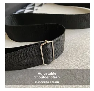 Dettaglio della tracolla regolabile in nylon nero con fibbia in metallo argentato