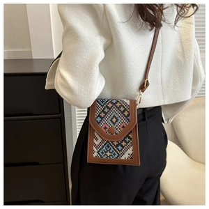 Detail of vintage ethnic crossbody phone bag with geometric woven pattern and leather strap
